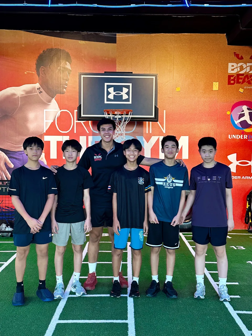Five teenage athletes with their strength coach under the basketball hoop at Body By Beast Underdogs, Bangkok